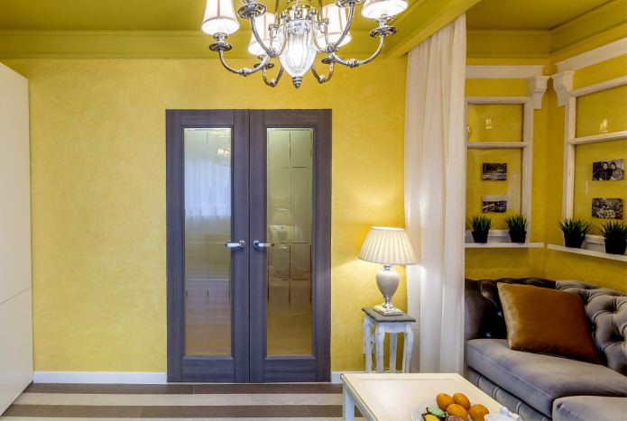 сочетание желтых стен с темно-коричневой дверью с стеклянными вставками