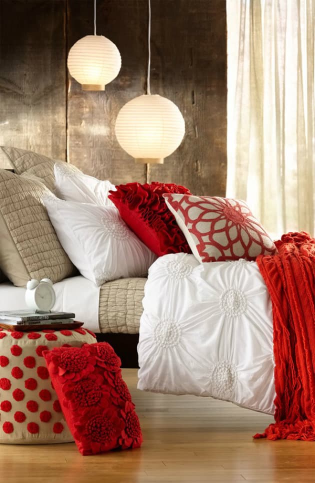 Сочетание белого с красным всегда дает положительный результат, а на фоне деревянных стен, интерьер спальни будет выглядеть более гармонично