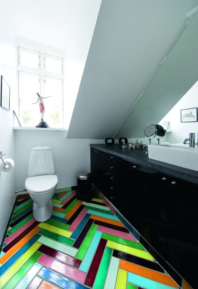 На пол в туалете уложена "елочкой" разноцветная яркая плитка