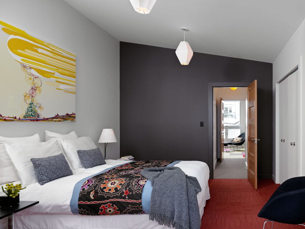 Эффектное цветовое сочетание черной стены и красного ковролина в спальне