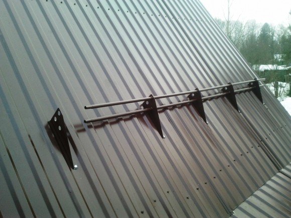 Трубчатый снегозадержатель на крыше из профнастила