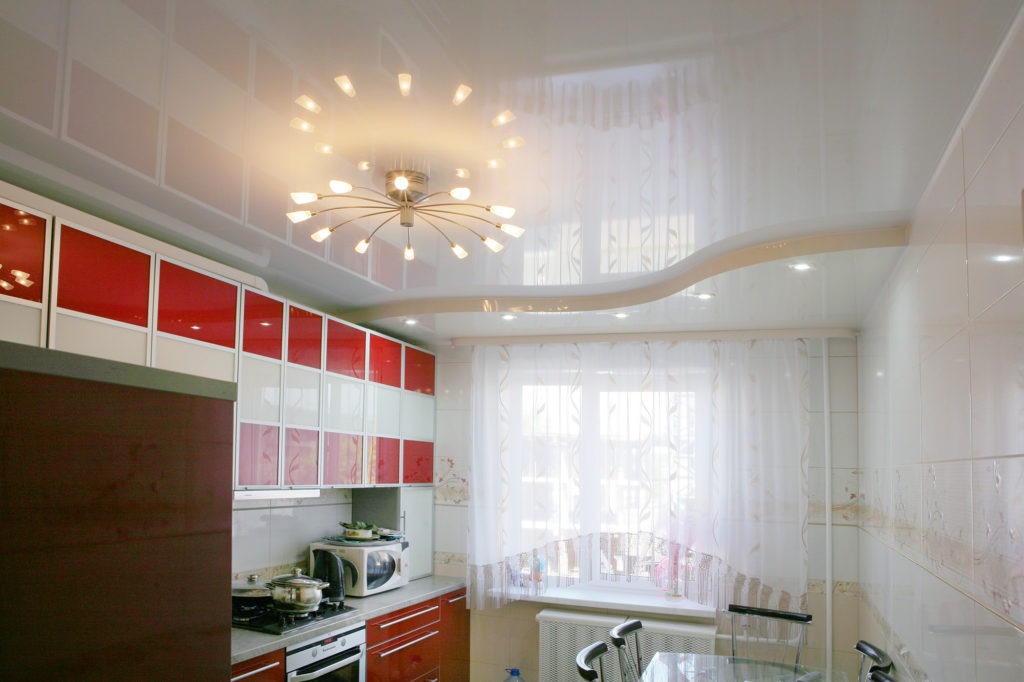 Белый глянцевый двухуровневый натяжной потолок на кухне