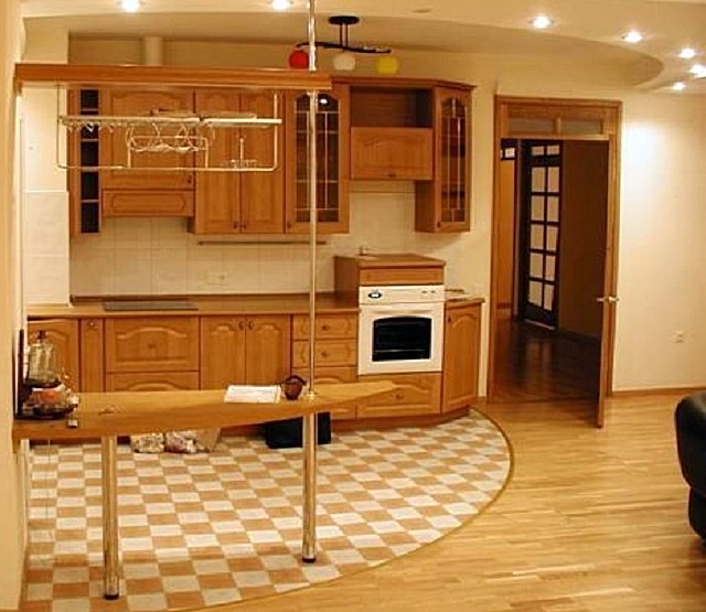 Плитка в зоне кухни и ламинат или паркет – в гостиной. Важно, чтобы переход был гармоничным, соответствующим общему дизайну объединенного помещения.