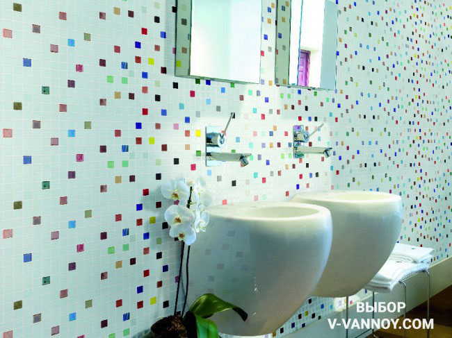 Разноцветные вставки на стене оживляют отделку и придают динамику интерьеру ванной. Цветные элементы не перегружают пространство, поскольку белый цвет преобладает в объеме, а предметы мебели и сантехника достаточно компактны.